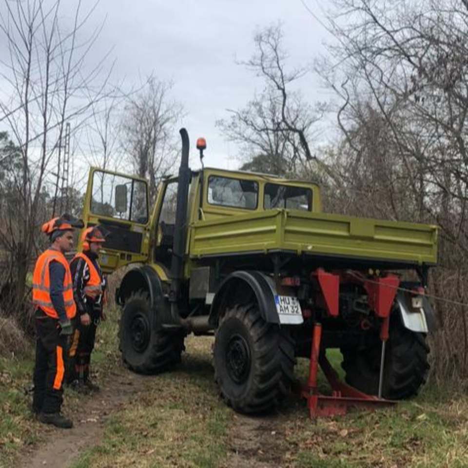 Gelber Traktor mit Arbeitern